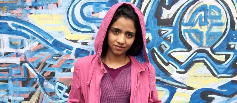 Sonita Alizadeh devant un mur de tags