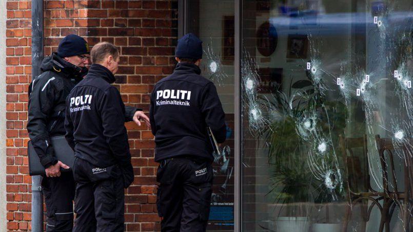 Des policiers danois relèvent les impacts de balles sur la facade d`un centre culturel de Copenhague où se déroulait, samedi, un débat sur la liberté d`expression.