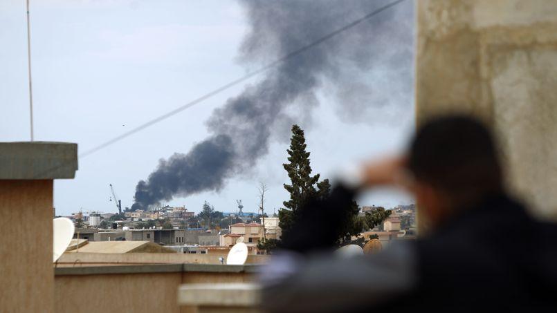 La fumée s'échappe du port de la ville libyenne de Benghazi le 14 février 2015 lors d'affrontements entre les forces loyales au gouvernement et les milices islamistes.