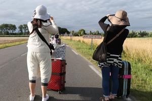  Two tourists with luggage towards Mont-Saint -Michel. 