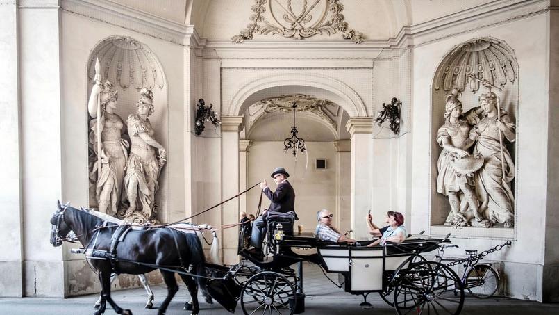 Un fiacre traversant la Hofburg, immense palais qui est une ville dans la ville. Vienne possède près de 150 fiacres, dont les conducteurs portent une tenue traditionnelle. Ces voitures et leurs chevaux font partie du paysage viennois