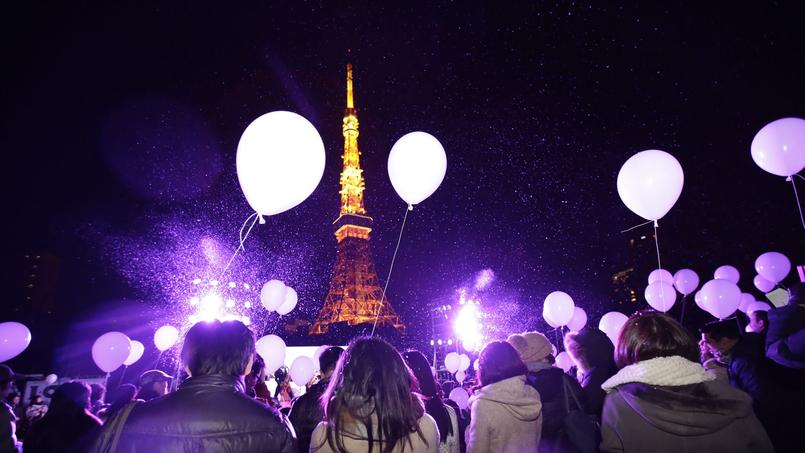 Japon. A Tokyo, les gens se préparent au lâcher de ballons qui célèbre le passage à la nouvelle année avec la Tour de Tokyo en arrière-plan.