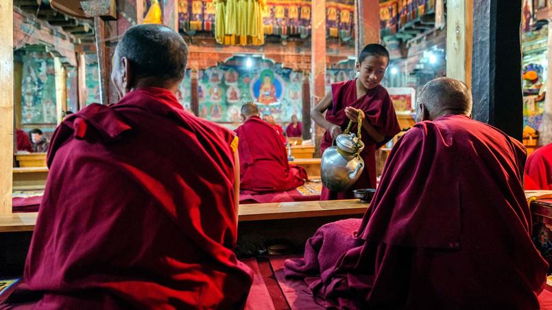 Pendant la première prière, au monastère de Thiksey. Un jeune moine sert du thé au lait de yak à ses maîtres. Le petit déjeuner n'interrompt pas la cérémonie: la vie du corps et la vie de l'âme ne font qu'un.