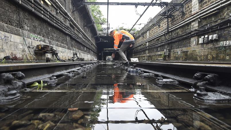 Un ouvrier réparant les dégâts causés par les inondations sur la ligne du RER C.