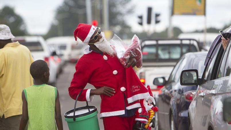 Un homme costumé en Père Noël dans les rues de Harare, la capitale du Zimbabwe, ce samedi. Dans ce pays autrefois prospère, la population à majorité chrétienne tente de maintenir l'esprit de Noël malgré la grave crise économique que connaît cet État.