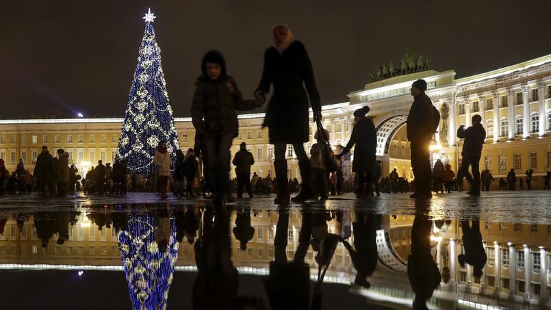 Des personnes marchent sur la place Dvortsovaya, à Saint-Pétersbourg, en Russie. La tradition veut que les Orthodoxes fêtent Noël la nuit du 6 au 7 janvier.