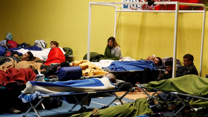 Des migrants se reposent dans un gymnase après l'incendie du camp de Grande-Synthe.