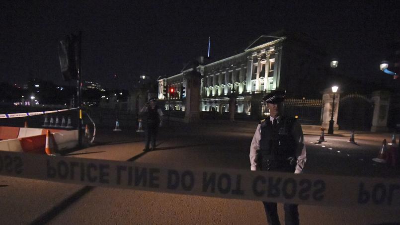 Un cordon de police est mis en place, vendredi soir devant le palais de Buckingham.