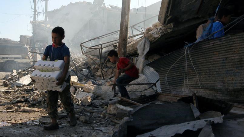 Des enfants sauvent ce qu'ils peuvent après un bombardement dans l'est d'Alep, ce lundi.