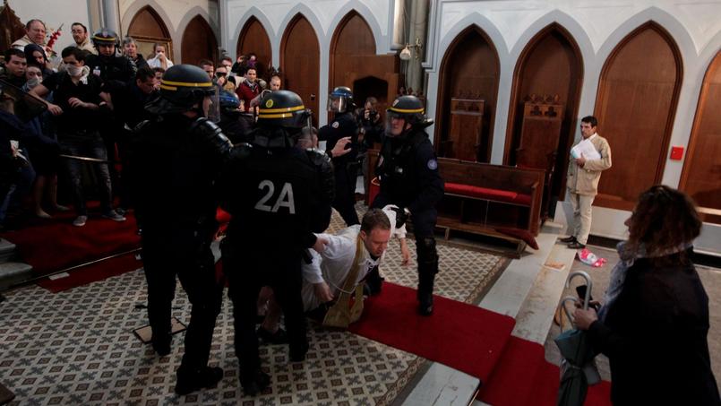 Un prêtre à terre pour resister à l'évacuation de l'église Sainte-Rita.