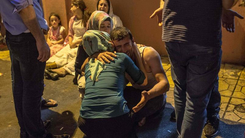 Une femme réconforte un homme en larmes à l'hôpital de Gaziantep, dans la nuit de samedi à dimanche