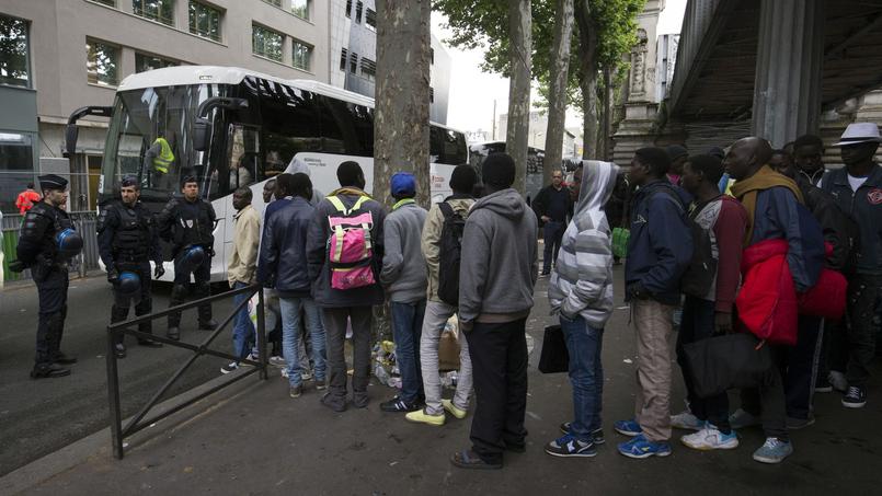 Des réfugiés pendant l'évacuation d'un camp à Paris.