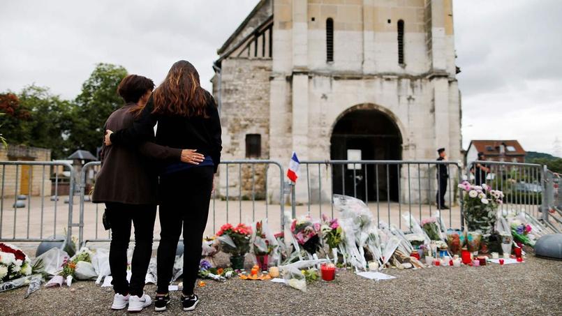Deux passantes se recueillent devant l'église de Saint-Etienne-du-Rouvray, après l'assassinat du père Jacques Hamel le 26 juillet 2016.