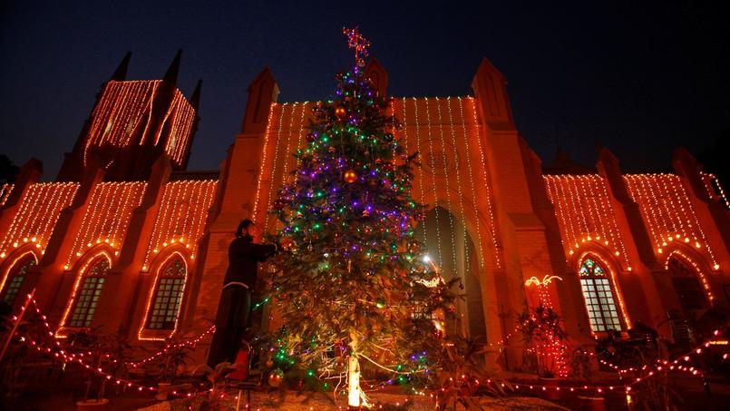 Un homme décore un sapin devant la cathédrale Saint-John, à Peshawar, au Pakistan, le 24 décembre 2016. 