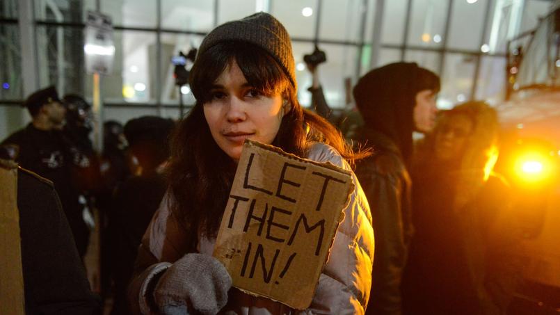 Des opposants au décret de Trump ont manifesté samedi à l'aéroport JFK de New York. Cette jeune femme dit sur sa pancarte: «laissez-les venir».