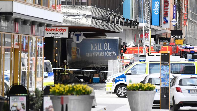 Tandis que les services de secours évacuent les blessés, la police sécurise le périmètre où un camion fou a percuté, vendredi, la devanture d'un grand magasin sur Drottninggatan, dans le centre de Stockholm..