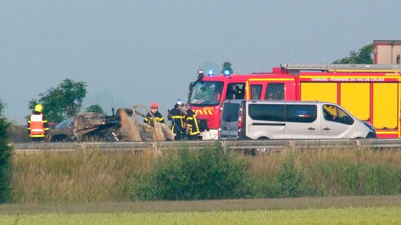 Des pompiers travaillent près de l'épave de la camionnette accidentée sur l'autoroute A16, le 20 juin 2017 près de Guemps, à une quinzaine de kilomètres de Calais.