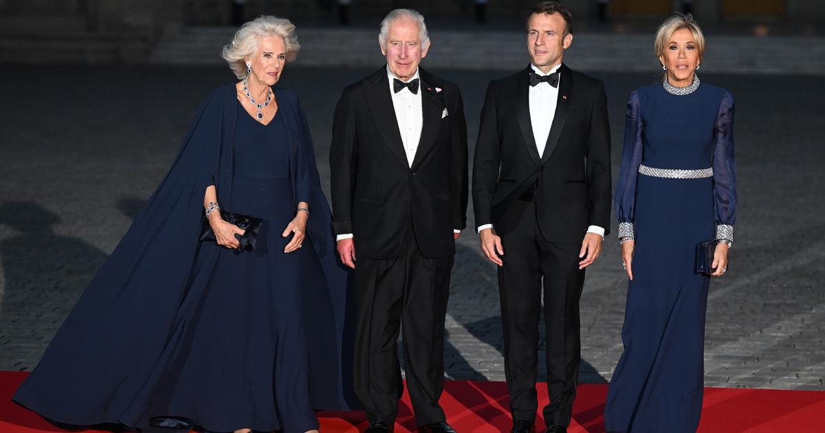 Dans une robe cape bleu nuit, la reine Camilla en parfaite symbiose avec Brigitte Macron à Versailles