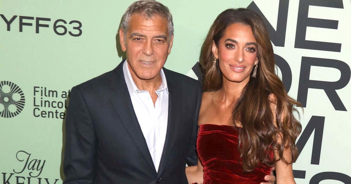 À New York, Amal Clooney surprend dans une robe cramoisie Oscar de la Renta au bras de George Clooney