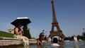 Les gens se rafraîchissent dans la fontaine du Trocadéro devant la Tour Eiffel, le 23 juin 2026.