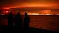 Des touristes observent depuis Gujan-Mestras l’incendie qui ravage la forêt autour du bassin d’Arcachon, en Gironde, le 24 juillet 2026.