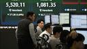 Des traders surveillent les taux de change tandis qu’un écran électronique affiche l’indice boursier de référence sud-coréen (KOSPI) et le KOSDAQ (Korean Securities Dealers Automated Quotations) dans une salle des marchés des changes du siège de la Hana Bank à Séoul, le 4 mars 2026.