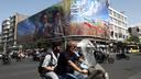 Des passants devant un panneau d’affichage représentant le défunt chef de la Révolution islamique, l’ayatollah Ruhollah Khomeini, et le défunt Guide suprême de l’Iran, l’ayatollah Ali Khamenei, dans une rue de Téhéran le 10 juin 2026.