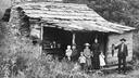« Family standing in front of cabin, near Mt. Sterling », lâhistoire de la pauvretĂ© dans les Appalaches formidablement revisitĂ©e par Stacy Kranitz dans les North Carolina Great Smoky Mountains National Park Archive.