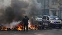 Un policier français éteint des vélos en feu lors des débordements en marge de la manifestation contre la vie chère à Paris, le 17 octobre 2026.