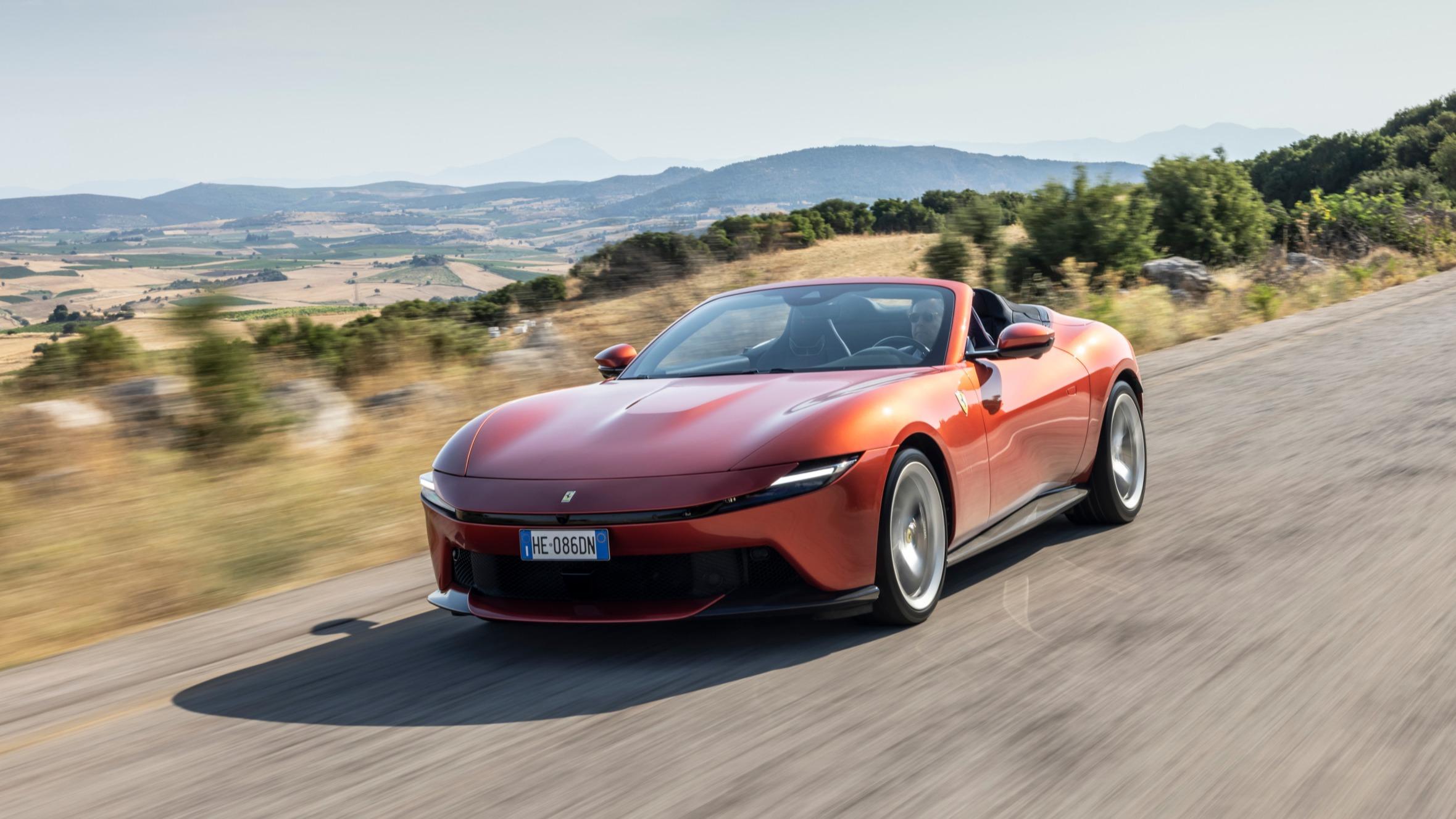 Une Ferrari spider rouge décapotée sur une route ensoleillée