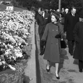 Elizabeth II devant les sépultures des 144 personnes qui sont décédées lors de la catastrophe d’Aberfan. (Aberfan, le 29 octobre 1966.)