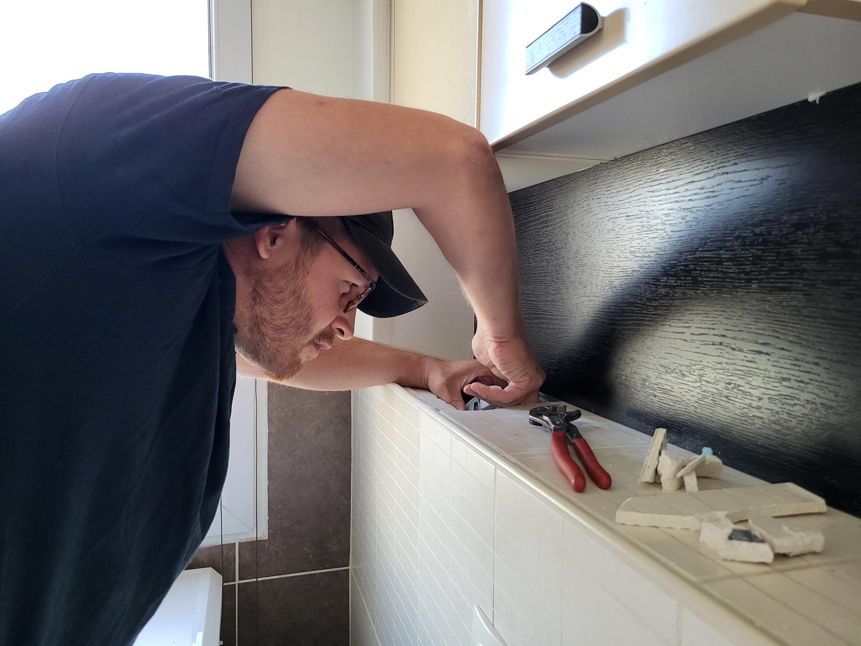 Un technicien Ista procédant aux changements des compteurs divisionnaires d’eau dans un immeuble de Courbevoie, en juillet 2025.