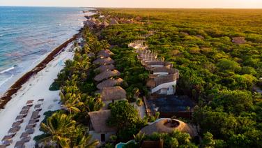 Quelles sont les meilleures activités à faire à Tulum ? Ici, une vue aérienne sur la plage au coucher de soleil.