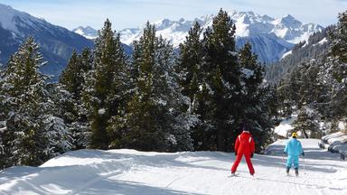 Deux skieurs dĂ©valent une piste enneigĂ©e dans les Alpes, oĂč les sĂ©jours au ski Ă©voluent entre hausse des prix, nouvelles attentes et recherche de flexibilitĂ©.