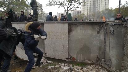 Des casseurs s'attaquent à la barre de fer au monument d'hommage situé place d'Italie à Paris.