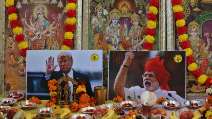 Des affiches de Donald Trump et du premier ministre indien Narendra Modi sont placées près d'images de divinités hindoues à New Delhi, ce lundi.