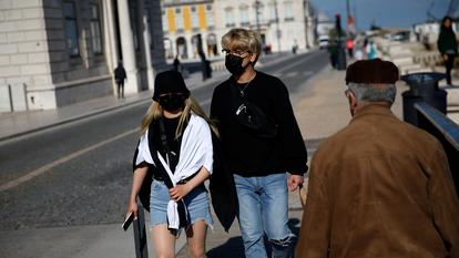 Des passants portent des masques de protection près de la place Comercio, à Lisbonne (Portugal), le 2 avril 2020, pour se protéger du Covid-19.