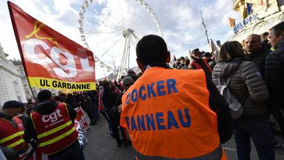 Des dockers du syndicat CGT se sont rassemblés lors d'une manifestation devant une grande roue sur le Vieux-Port de Marseille, dans le sud de la France, le 14 janvier 2020.