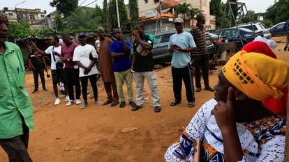 Les gens attendent pour voter lors de l’élection présidentielle, dans un bureau de vote à l’intérieur d’une école, à Abidjan, Côte d’Ivoire, le 25 octobre 2025.