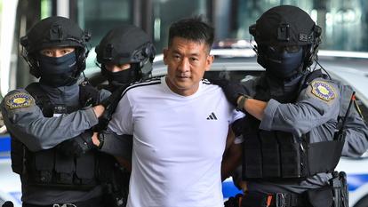 Le roi du jeu She Zhijiang, 43 ans, est escorté par la police thaïlandaise avant d’être extradé vers la Chine, le 12 novembre 2025 à Bangkok.