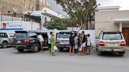 Des touristes se tiennent devant un hôtel sur l’île Socotra, au Yémen, le 5 janvier 2026.