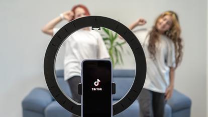 Deux adolescentes se filment devant un smartphone et l’application TikTok..
