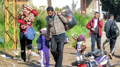 Des familles syriennes alaouites pénètrent dans le nord du Liban après avoir traversé le fleuve Nahr al-Kabir, à la frontière avec la province côtière occidentale de Syrie le 11 mars 2025.