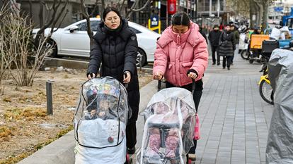 Des femmes poussent des poussettes dans une rue de Pékin, le 4 janvier 2026. Dix ans après avoir abandonné sa politique stricte de l’enfant unique et mis en place une politique des deux enfants en janvier 2016, la Chine est confrontée à une crise démographique imminente.