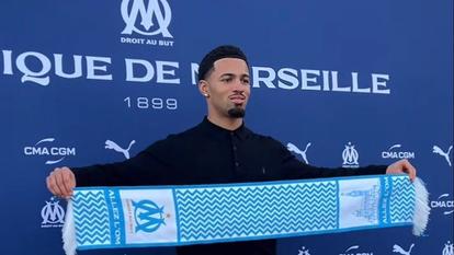 Joueur de football en tenue d'équipe faisant une action défensive sur un terrain de football