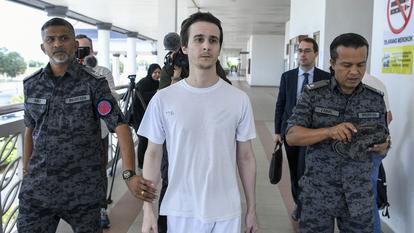 Le ressortissant français Tom Félix marche en compagnie d’agents de l’immigration malaisienne après avoir été acquitté de huit chefs d’accusation liés au trafic de drogue par la Haute Cour d’Alor Setar le 3 février 2026.