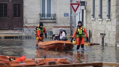 Des pompiers aident des habitants à bord d’un bateau lors d’une crue de la Charente à Saintes, le 17 décembre 2023.