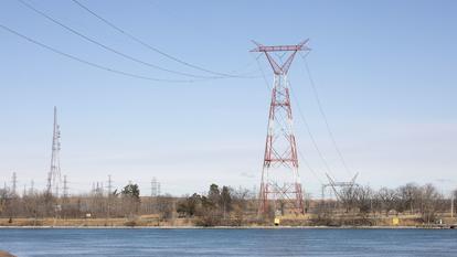 Des lignes électriques à haute tension traversent la rivière Saint-Clair entre le Canada (à l’arrière-plan) et les États-Unis, le 8 mars 2025, à East China Township, dans le Michigan.