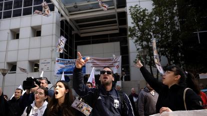 Des marins grecs lancent de faux billets de dollars en l’air lors d’une manifestation devant le siège de l’Union des armateurs grecs.