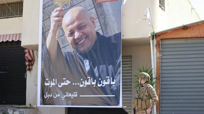 Un soldat libanais devant le portrait du père Pierre.